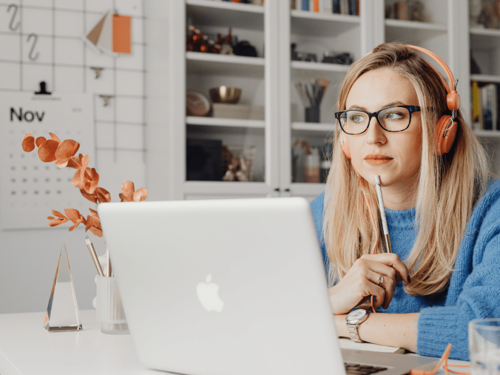 Frau vor Laptop überlegt, warum sie einen Onlinekurs erstellen sollte