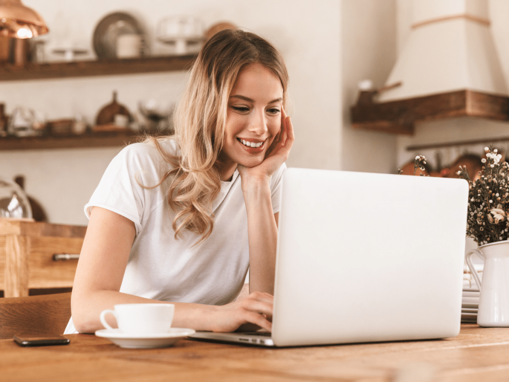 Frau erstellt Onlinekurs vor dem Laptop in der Küche